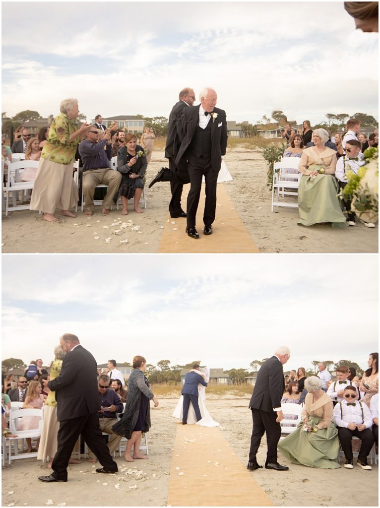 Bride + Groom's parents high five each other after the wedding ceremony on the beach