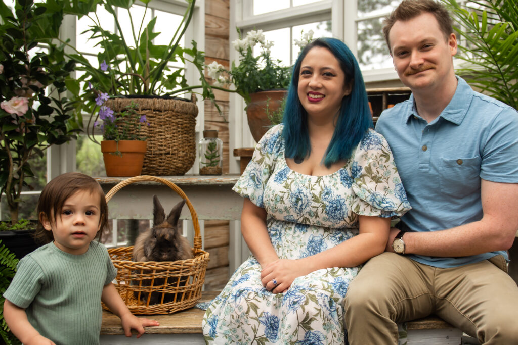 family pose for easter mini session in the greenhouse with Archie the bunny at prospect farms in Lawrenceville, Ga