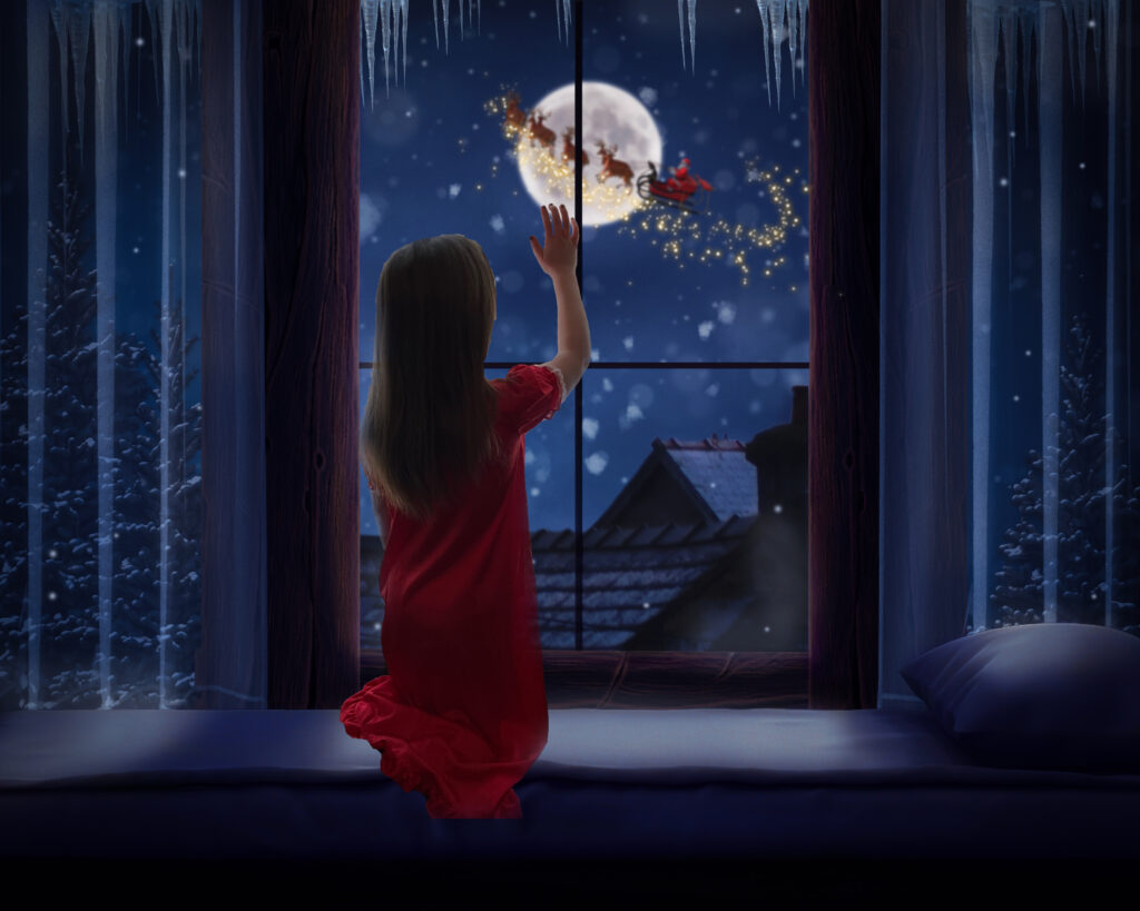 composite of a girl sitting in the window seal watching santa and his reindeer fly in the sky