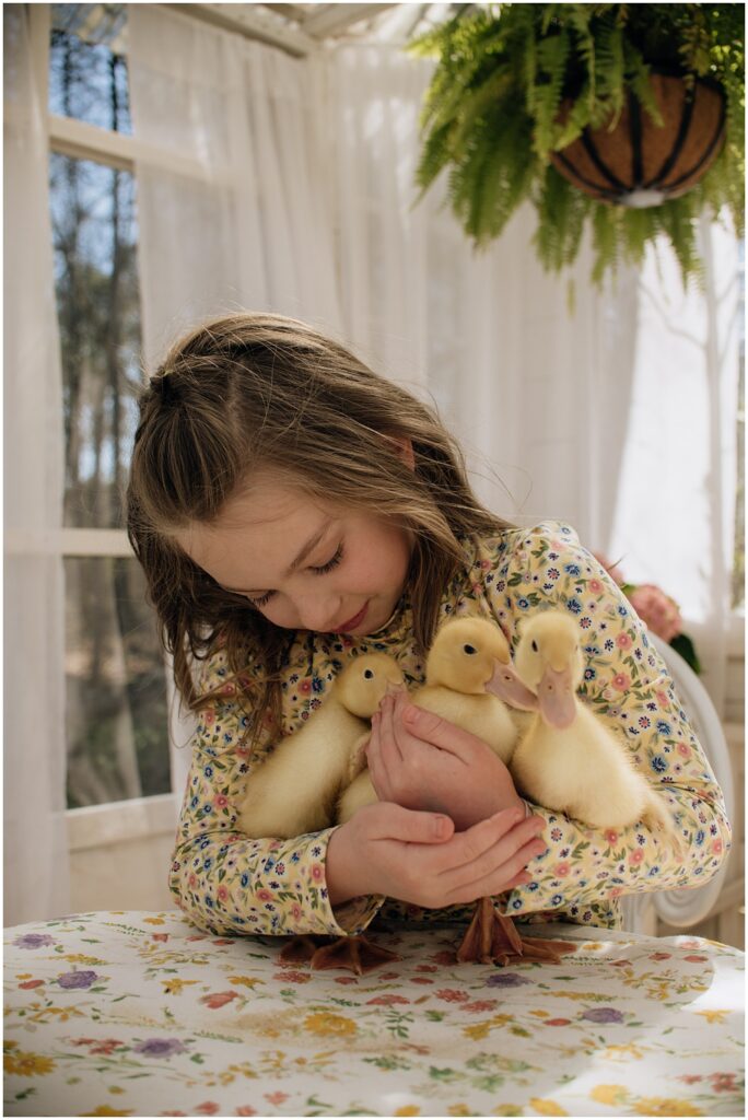 Flowery Branch photographer photographs a Spring, Easter mini with live baby ducks at Mayberry Acres, in Canton Georgia. Session was held outside in the greenhouse.