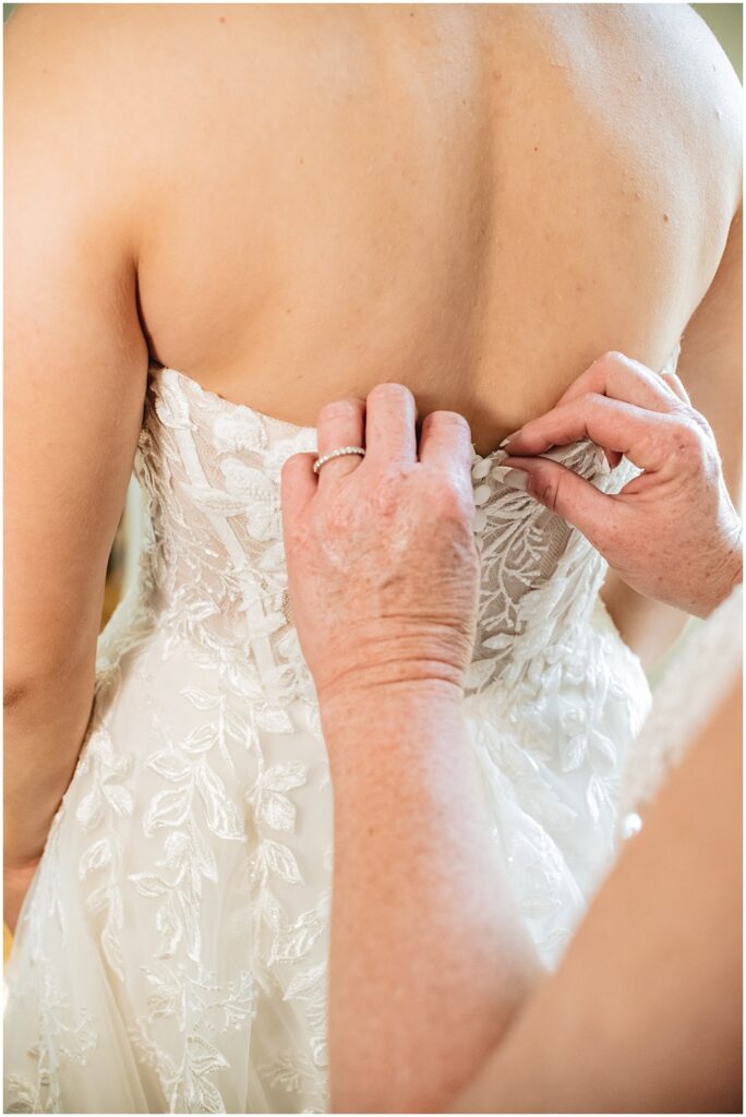 North Georgia photographer photographs the Bride's mom helping her button her wedding dress