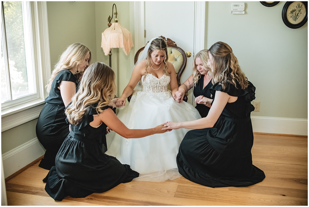 North Georgia photographer photographs the Bride praying with her Bridesmaids